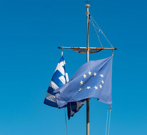 Low angle view of crane against clear blue sky