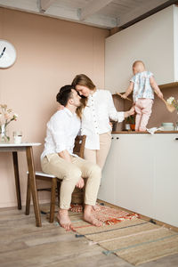 Lovely family of three in kitchen. mom hugs and looks tender at dad.