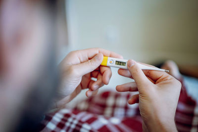 Midsection of woman holding thermometer