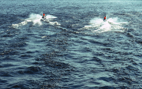 People on jet boats in sea