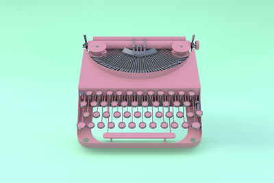 Pink typewriter floating on a green pastel background. minimal concept.