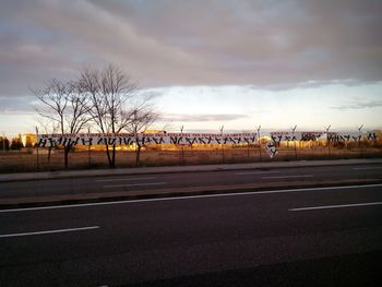 Road against cloudy sky at sunset