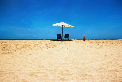 Lifeguard hut on beach against blue sky