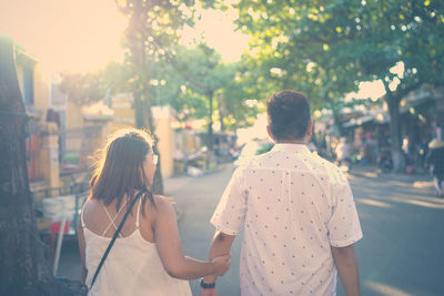 Rear view of couple walking on street