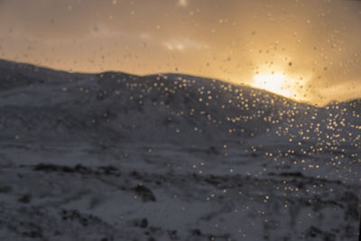 Close-up of wet beach against sky during sunset