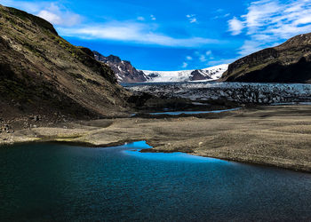 Scenic view of lake and mountains against blue sky