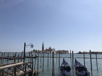 View of wooden post in canal against clear sky