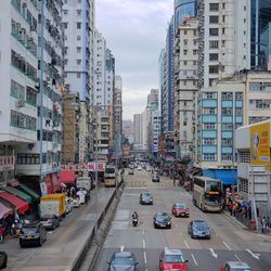 Traffic on city street by buildings against sky