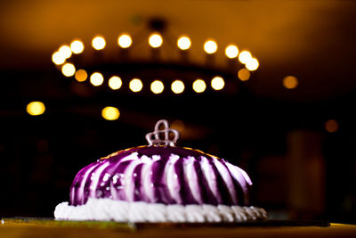 Close-up of illuminated candles on table at night