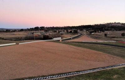 Scenic view of agricultural field against clear sky during sunset