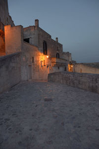 Illuminated buildings in city against clear sky at dusk