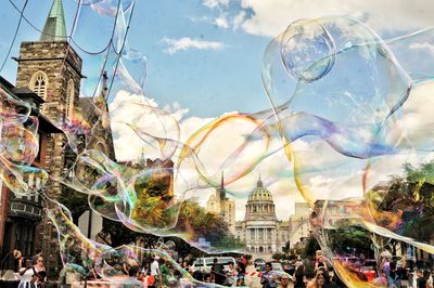 Digital composite image of bubbles and buildings in background