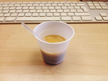 Coffee close to keyboard on home office desk table