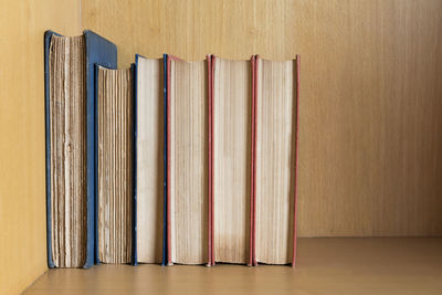 Close-up of books in wooden shelf