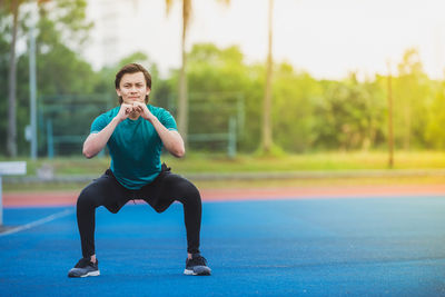 Portrait of young man exercising at stadium