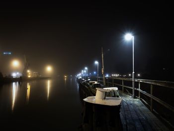 Illuminated street lights on pier at night