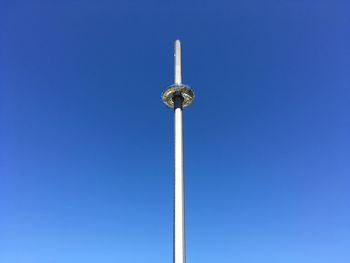 Low angle view of communications tower against blue sky