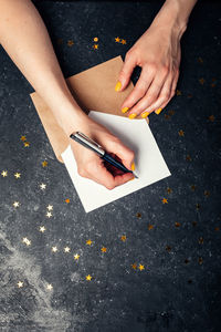 A woman writes plans for 2022 on black background top view