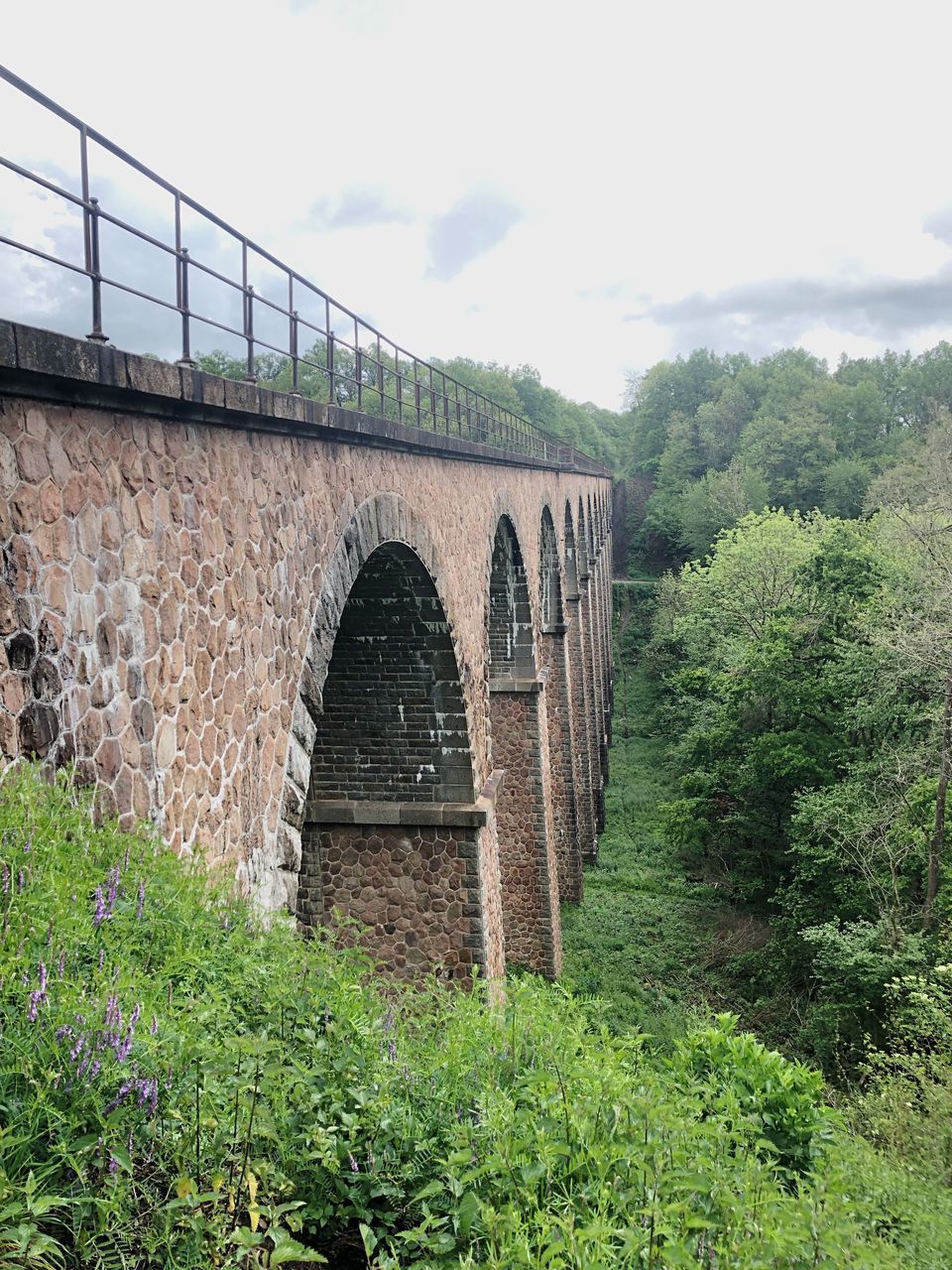 ARCH BRIDGE ON GRASS AGAINST SKY