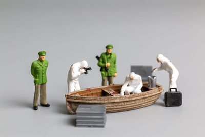 Miniature people police and detective are working on the boat , crime scene investigation concept