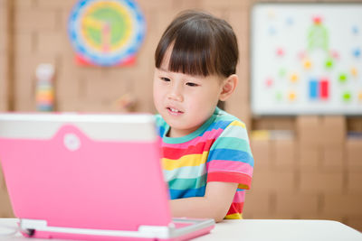 Portrait of cute boy sitting on table