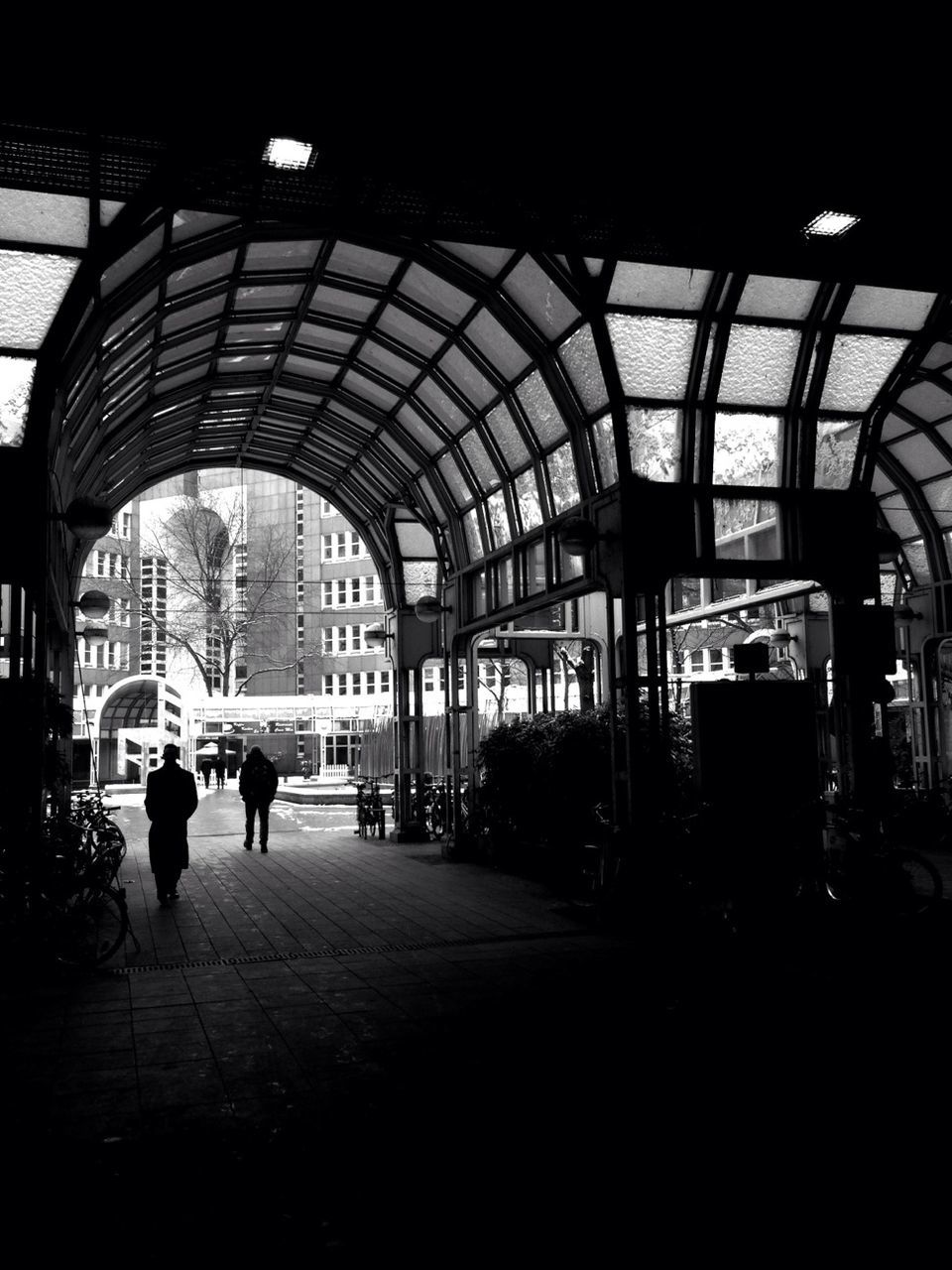 architecture, built structure, arch, indoors, men, walking, person, building exterior, architectural column, railroad station, city, lifestyles, travel, large group of people, incidental people, city life, full length, transportation, illuminated