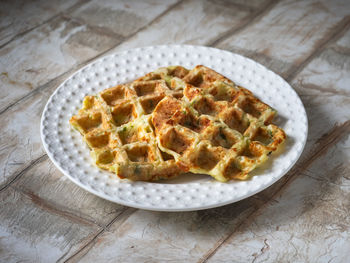 Vegetable waffles on a white plate. zucchini waffles with herbs and cheese.