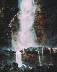 Low angle view of waterfall at rocky mountains
