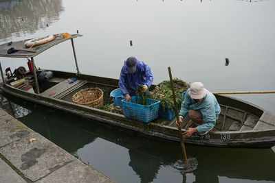 Men working on boat in lake