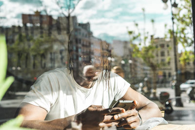 Midsection of man using smart phone on street