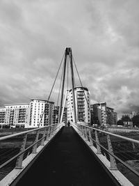 View of suspension bridge against cloudy sky