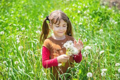 Smiling girl holding dandelion seed