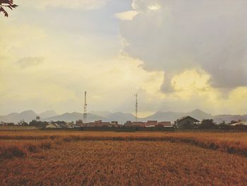 Scenic view of field against cloudy sky