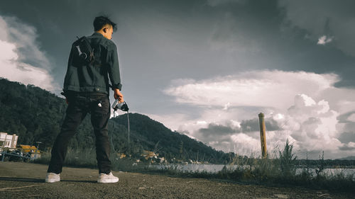 Man standing on mountain against sky