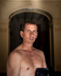 Portrait of shirtless man looking at camera
