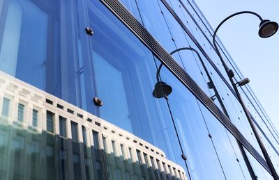 Low angle view of building against sky with street light and reflection