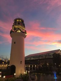 Low angle view of illuminated building against sky during sunset