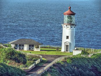 Lighthouse by building against sea