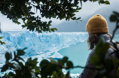 Rear view of woman looking at trees during winter