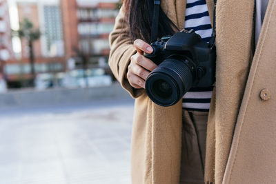 Midsection of man photographing in snow