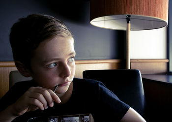Close-up of boy looking away while sitting at home
