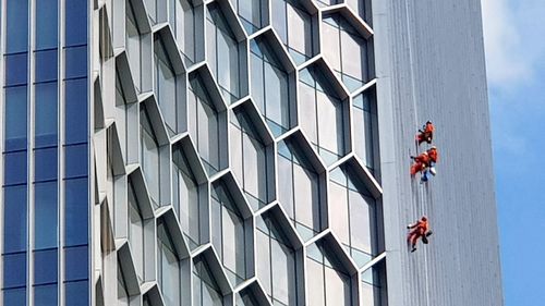 People working on glass building