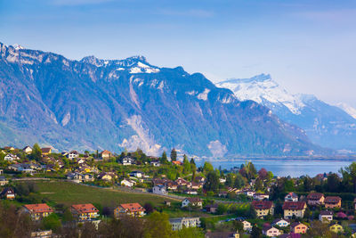 Scenic view of townscape and mountains against sky