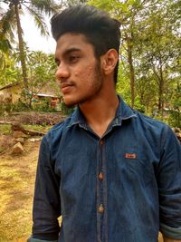 Portrait of young man standing in forest