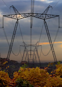 Electricity pylon against sky during sunset