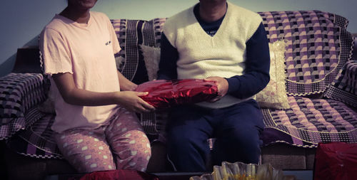 Rear view of couple kissing on sofa