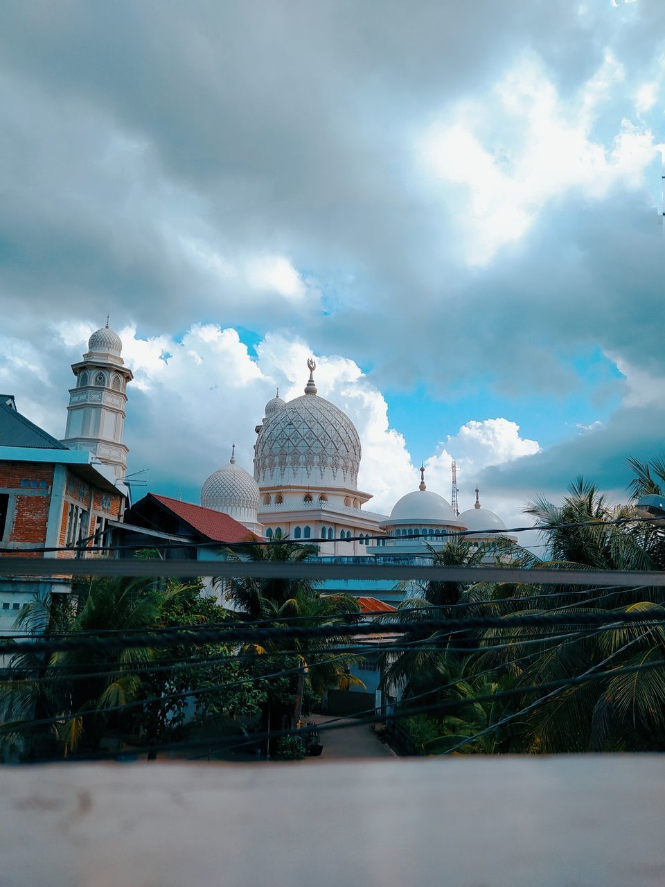 architecture, cloud, sky, built structure, building exterior, travel destinations, religion, dome, travel, building, belief, nature, place of worship, tourism, spirituality, landmark, city, vacation, reflection, sea, no people, plant, blue, outdoors, tree, tropical climate, urban area, cityscape, water, environment, history, the past