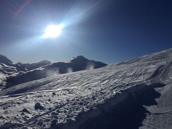 Scenic view of snowcapped mountains against sky on sunny day