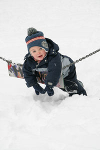 Portrait of boy playing on snow covered field