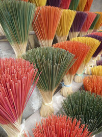 Close-up of multi colored brooms for sale in market